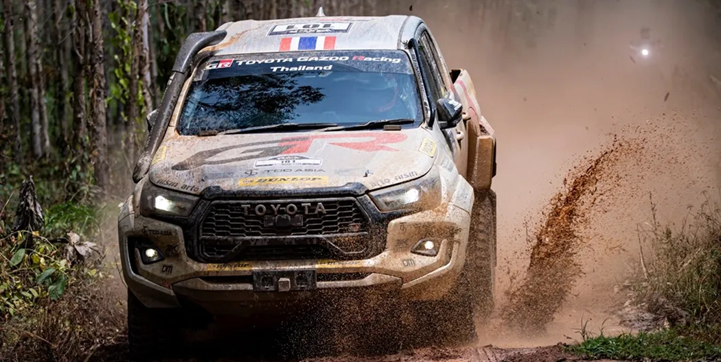Rally car racing through muddy terrain