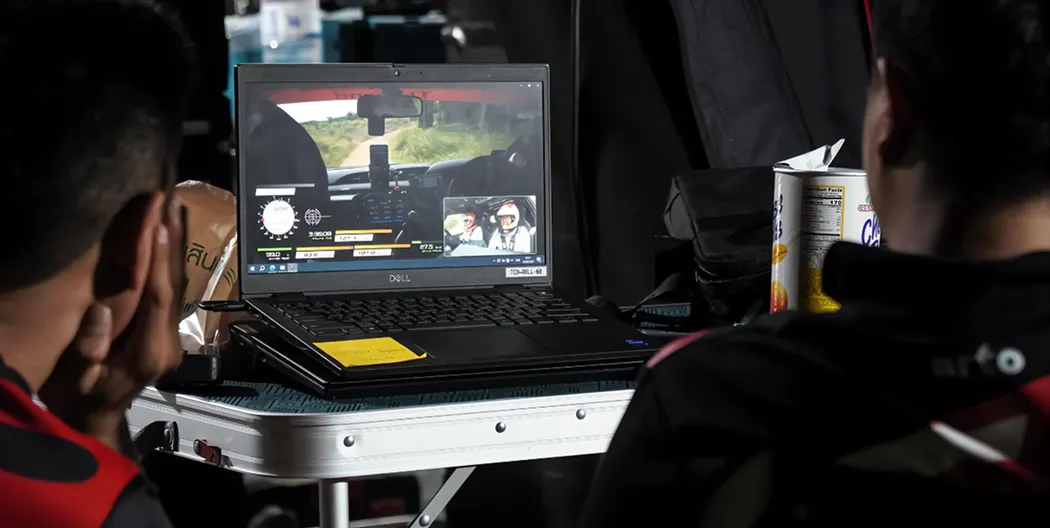 Technical support team analyzing race data on laptop